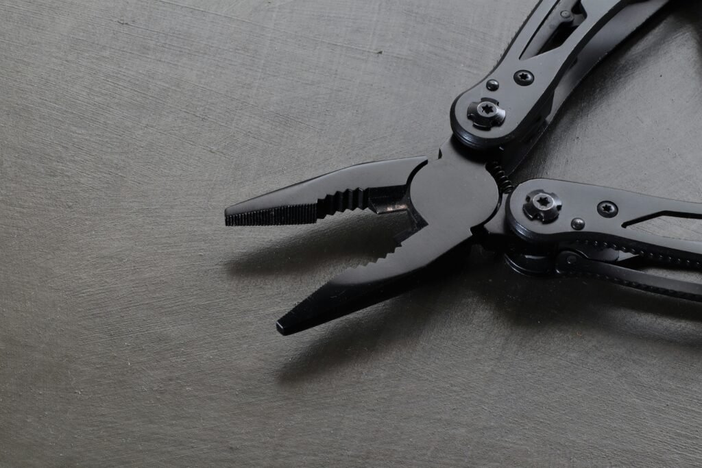 Black metal pliers on a dark surface, emphasizing industrial precision and durability.