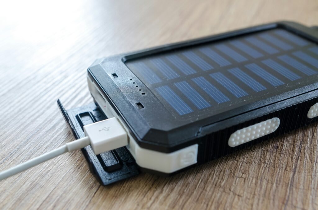 A close-up of a solar charger with a USB connection on a wooden surface, showcasing modern technology.