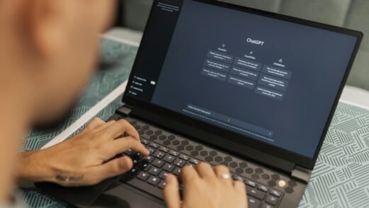 Close-up of a person typing on a laptop displaying the ChatGPT interface, emphasizing modern technology use.